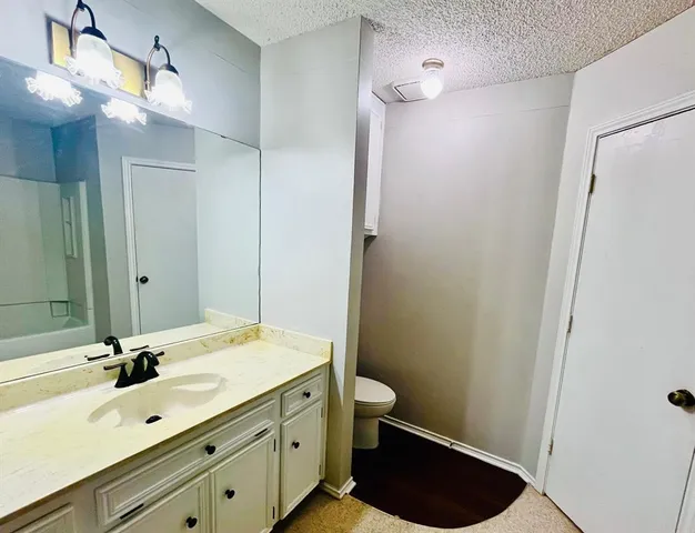 a bathroom with a double vanity sink a toilet and a mirror