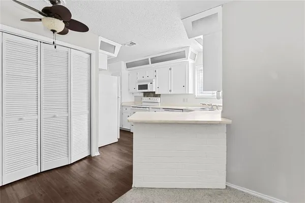 a kitchen with stainless steel appliances a sink cabinets and wooden floor