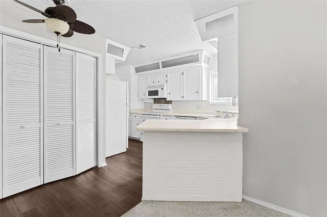 a kitchen with stainless steel appliances a sink cabinets and wooden floor