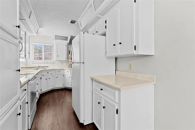 a kitchen with cabinets and wooden floor