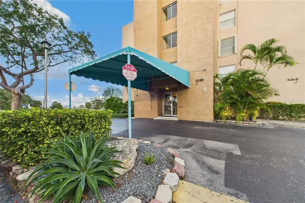 a front view of a house with a yard and potted plants