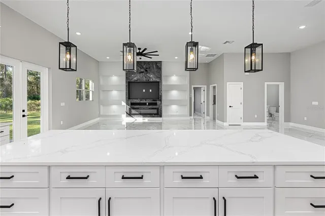 a kitchen with granite countertop white cabinets and stainless steel appliances