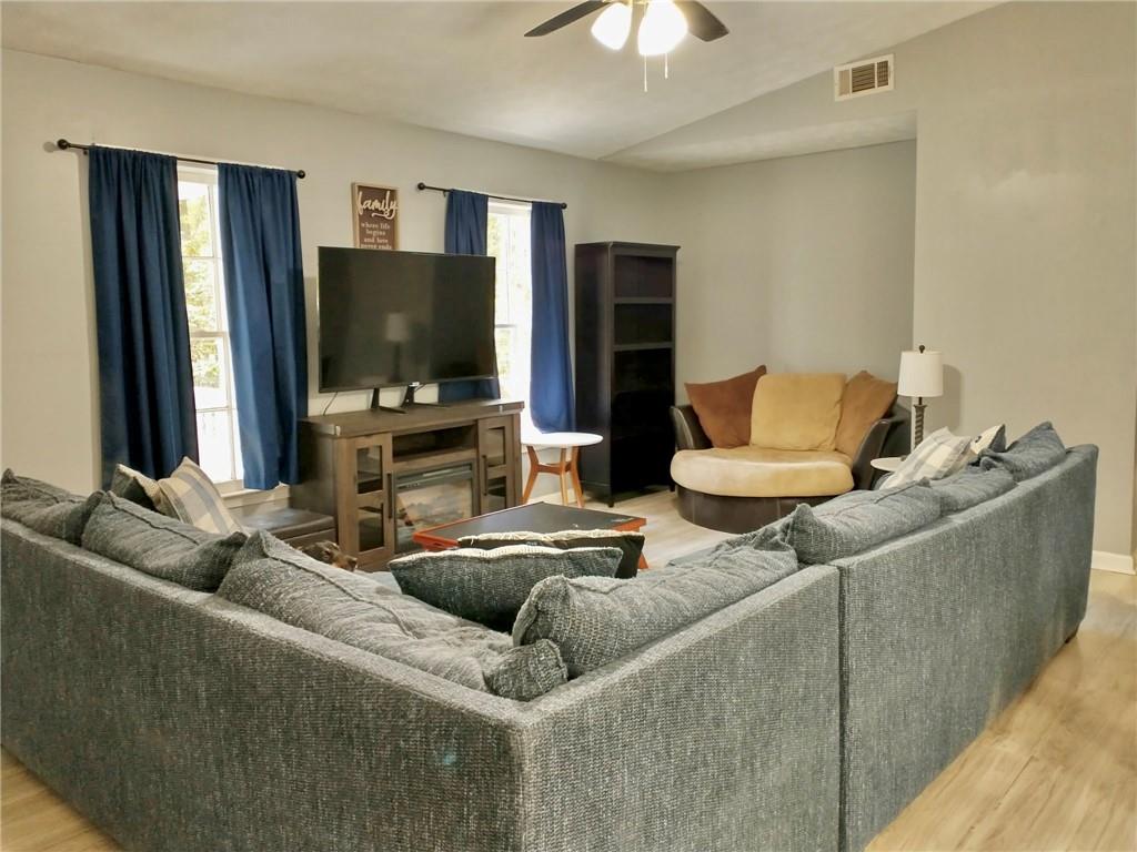 766 Country Club Road Newnan, GA 30263 - Photo 8 of 34 Living room featuring light wood-style flooring, healthy amount of natural light, vaulted ceiling, and a ceiling fan