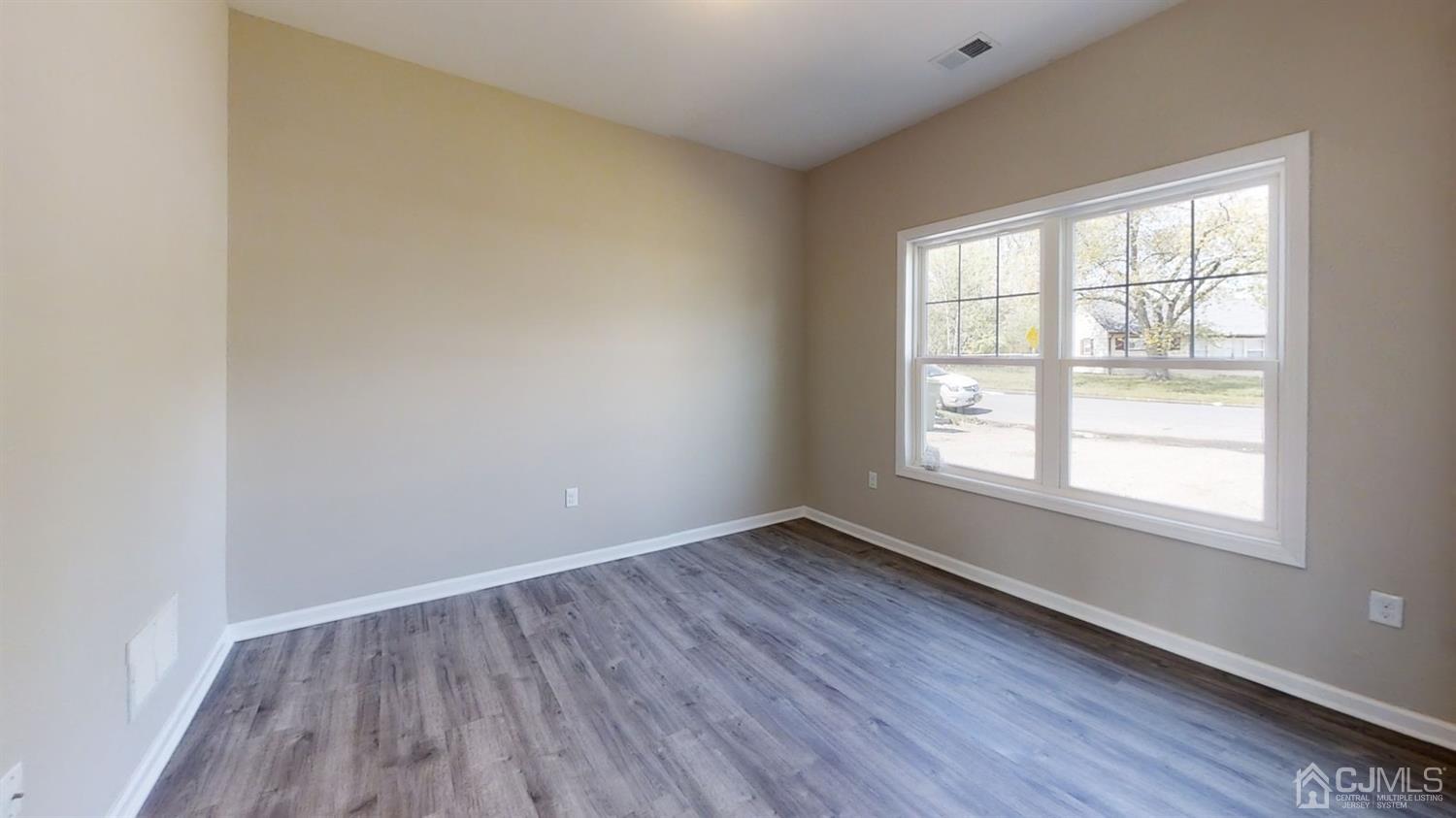 16 Idlewild Road Edison, NJ 08817 - Photo 8 of 15 an empty room with wooden floor and windows
