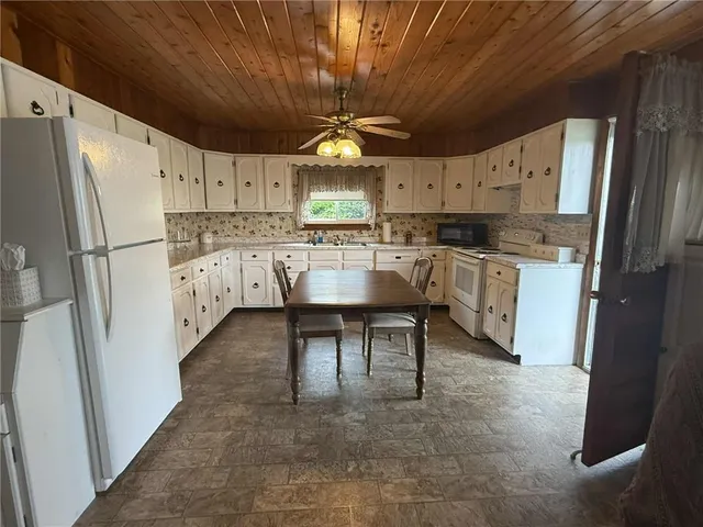 a kitchen with refrigerator and cabinets