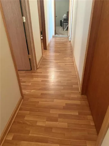 a view of a hallway with wooden floor and staircase