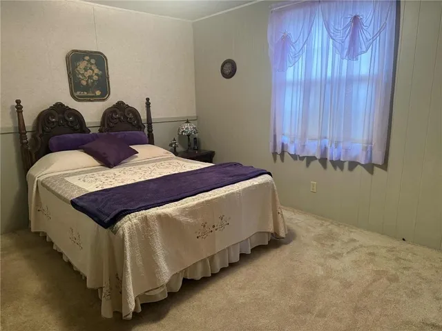 a bedroom with a bed and painting on the wall