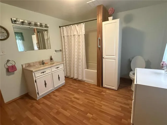 a view of a kitchen with fridge and wooden floor