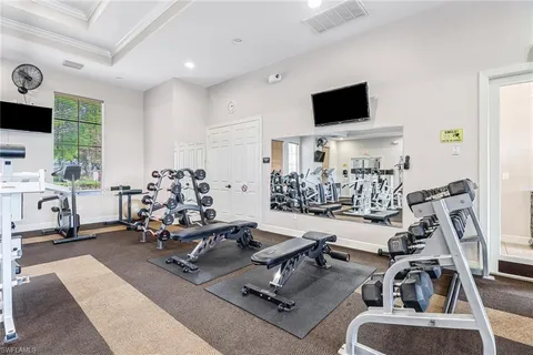 a room with gym equipment and a flat screen tv