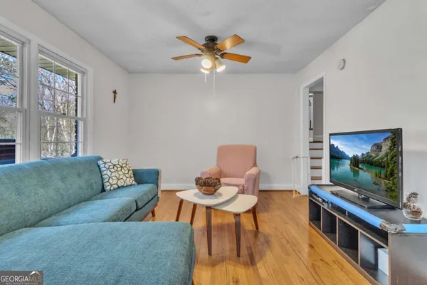 a living room with furniture a flat screen tv and a window