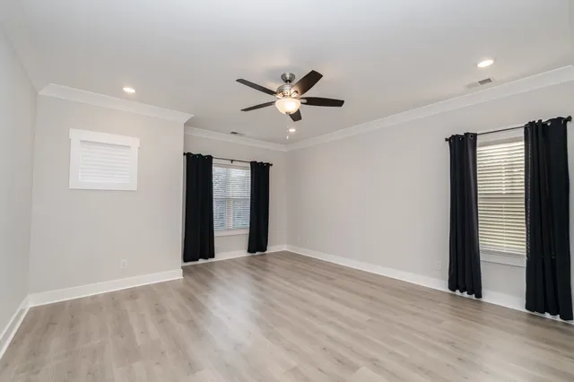 a view of an empty room with a ceiling fan and a window