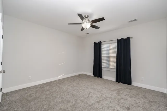 an empty room with closet and windows