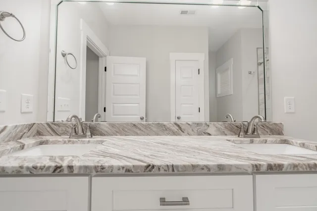 a bathroom with double vanity sinks and a mirror