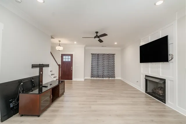 a view of an empty room with fire place and a flat screen tv