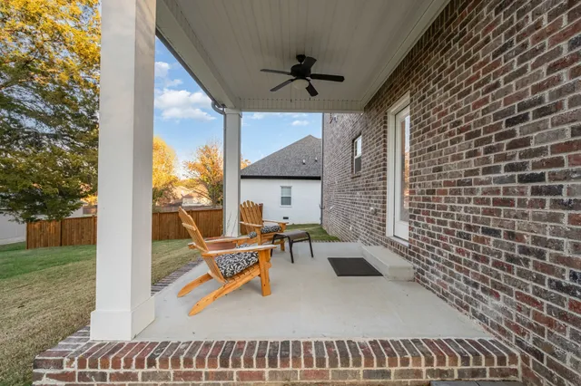 a view of a patio with a table chairs and a floor to ceiling window