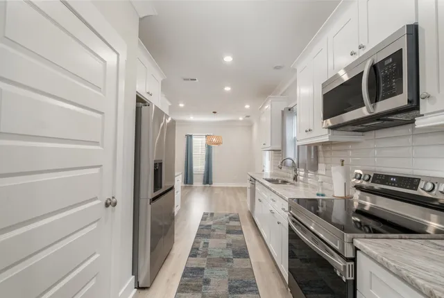a kitchen with stainless steel appliances a stove microwave and cabinets