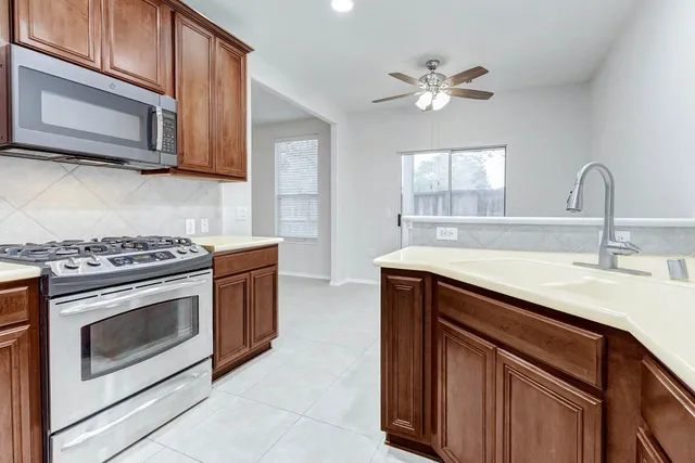 a kitchen with stainless steel appliances granite countertop a sink stove and microwave