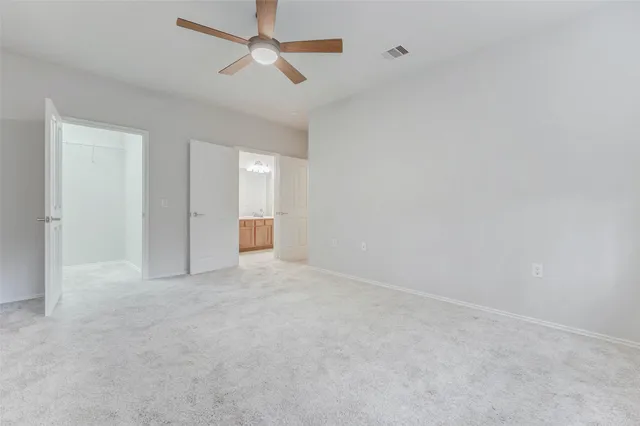 a view of an empty room with a ceiling fan