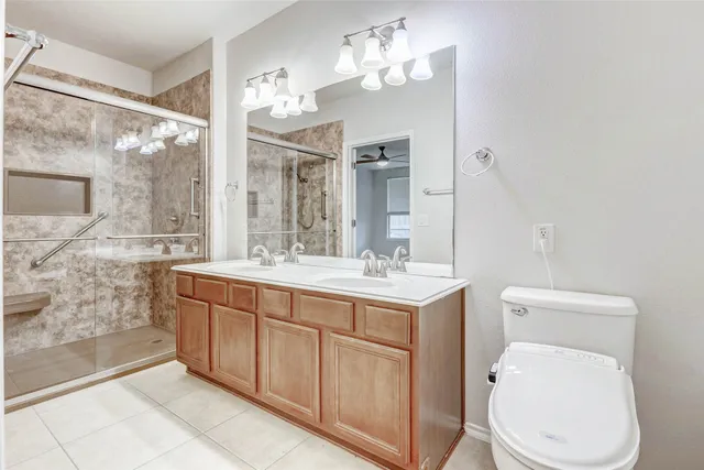 a spacious bathroom with a granite countertop toilet sink and mirror