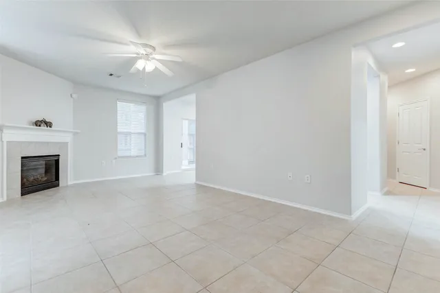 an empty room with fireplace and fan