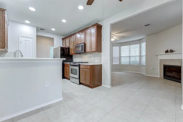 a kitchen with stainless steel appliances granite countertop a stove a sink and a refrigerator