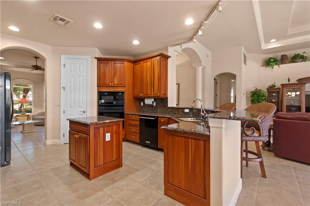 8855 Largo Mar Drive Estero, FL 33967 - Photo 13 of 50 an open kitchen with stainless steel appliances granite countertop a stove and cabinets