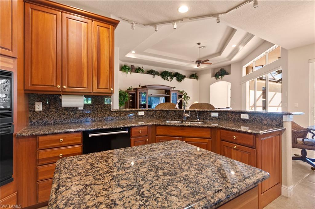 8855 Largo Mar Drive Estero, FL 33967 - Photo 14 of 50 a kitchen with stainless steel appliances granite countertop a stove a sink dishwasher and cabinets with wooden floor