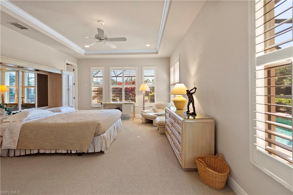 8855 Largo Mar Drive Estero, FL 33967 - Photo 18 of 50 a spacious bedroom with a bed and glass windows