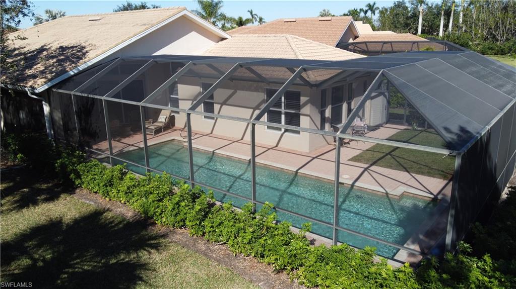 8855 Largo Mar Drive Estero, FL 33967 - Photo 38 of 50 a view of a patio with table and chairs under an umbrella with a small garden