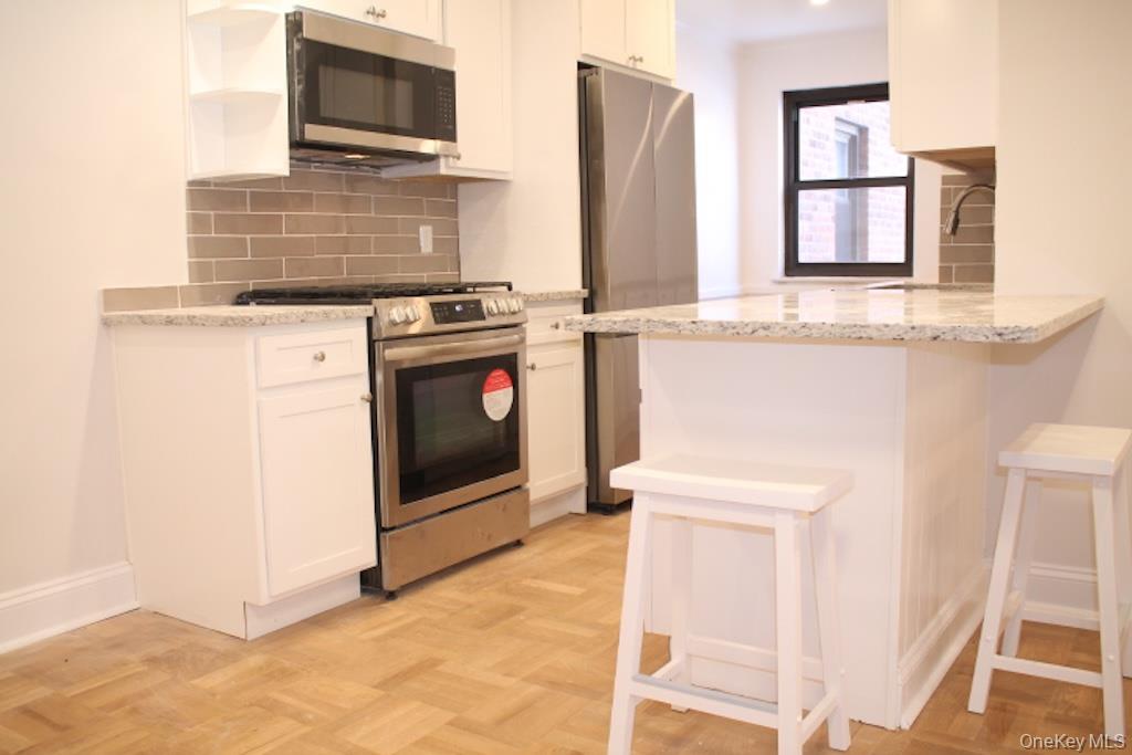 50 White Oak Street, Unit 1C New Rochelle, NY 10801 - Photo 1 of 24 a kitchen with a stove and a microwave