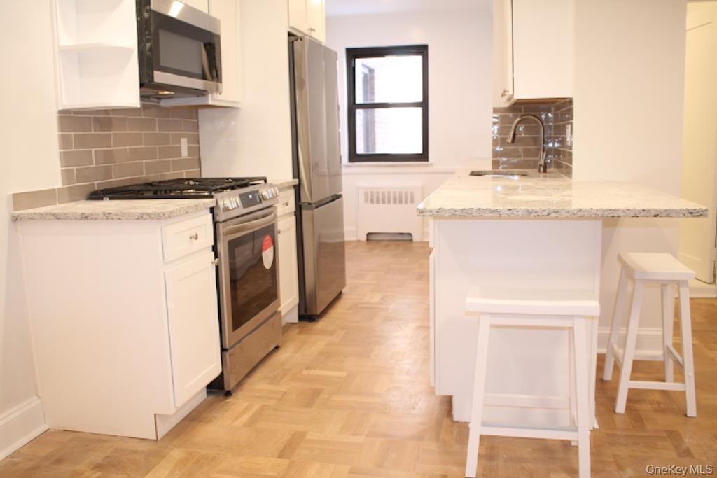 50 White Oak Street, Unit 1C New Rochelle, NY 10801 - Photo 3 of 24 a kitchen with granite countertop a stove and a refrigerator