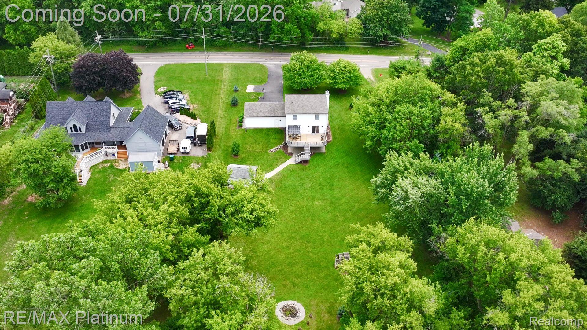 2401 Golf Club Road Howell, MI 48843 - Photo 31 of 37 Expansive property featuring two distinct residences, a sprawling lawn, mature trees, and a visible fire pit