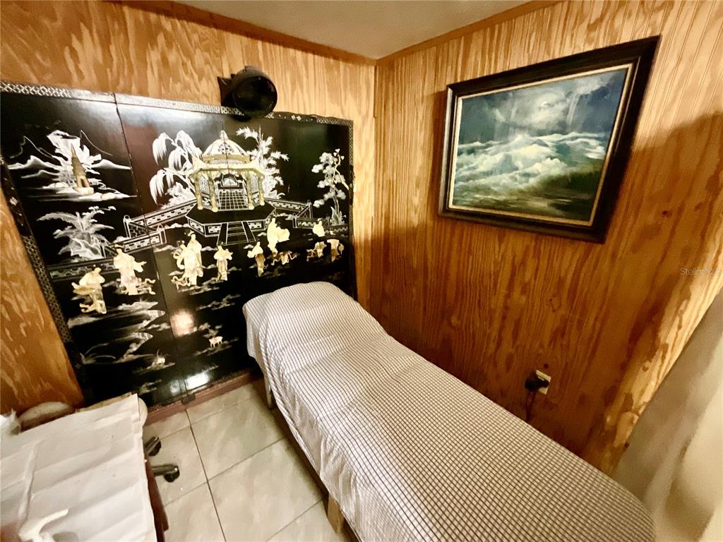 5124 Trouble Creek Road New Port Richey, FL 34652 - Photo 13 of 32 a bedroom with a bed and a painting on the wall