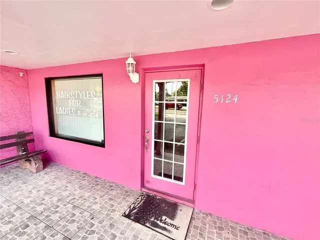 a view of a red brick wall with window in front of it
