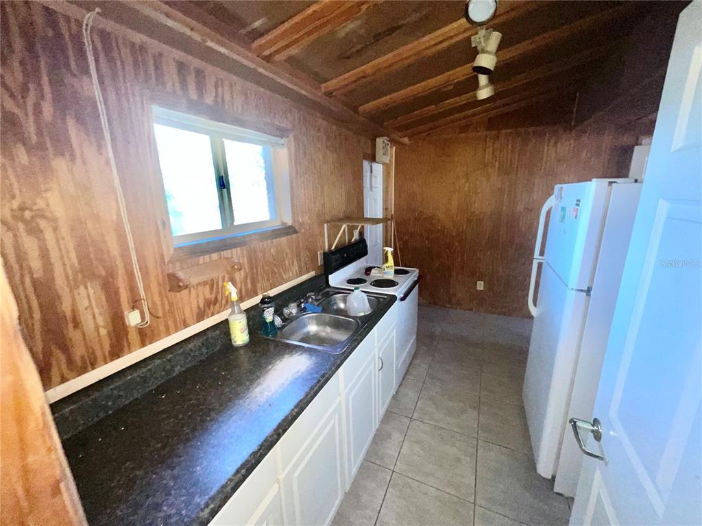 5124 Trouble Creek Road New Port Richey, FL 34652 - Photo 26 of 32 a kitchen with stainless steel appliances granite countertop a sink stove and cabinets