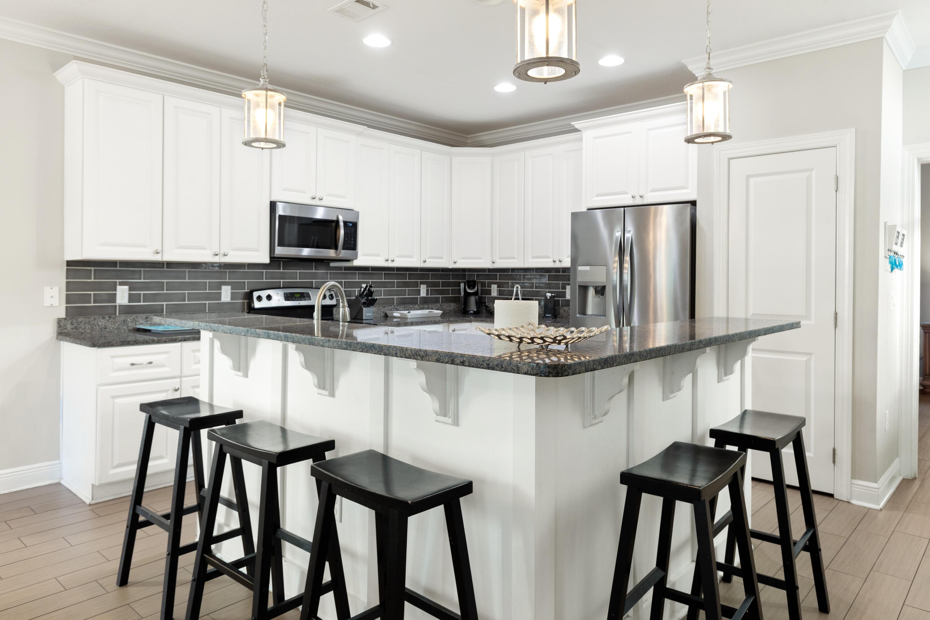 207 Kono Way Destin, FL 32541 - Photo 12 of 45 a kitchen with stainless steel appliances granite countertop a table chairs microwave and sink