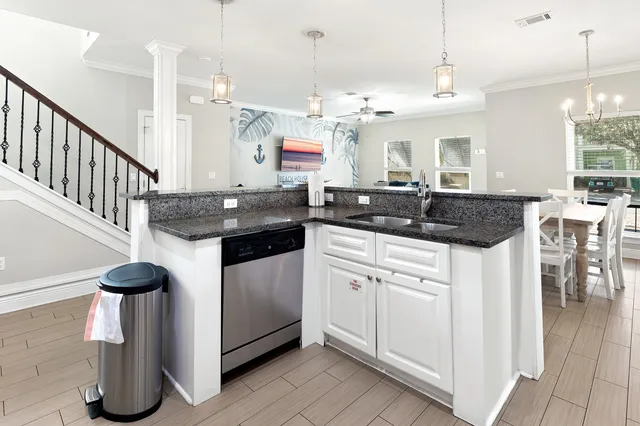 a kitchen with stainless steel appliances kitchen island granite countertop a sink and a white cabinets