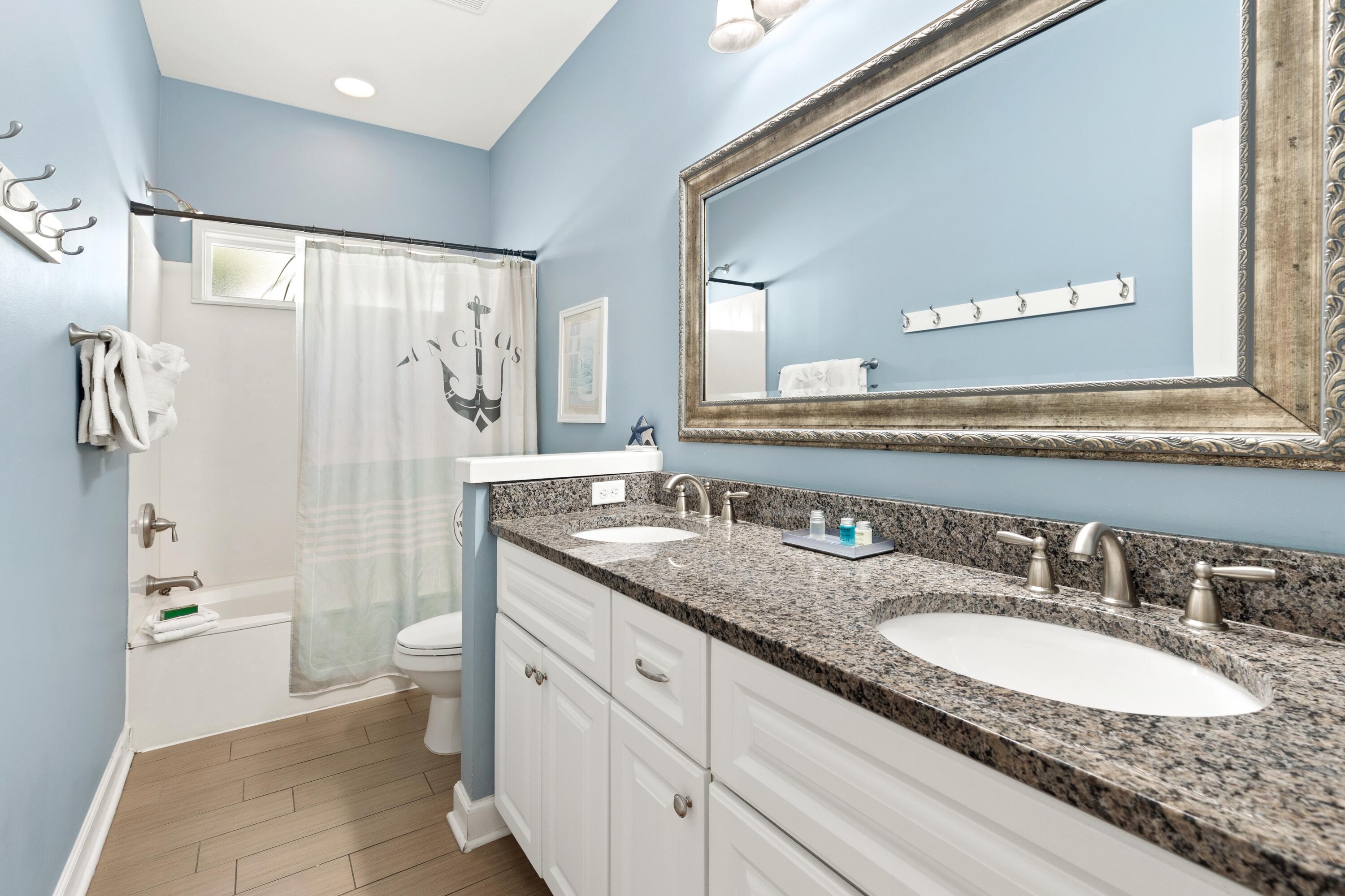207 Kono Way Destin, FL 32541 - Photo 24 of 45 a bathroom with a granite countertop double vanity sink toilet mirror and bathtub