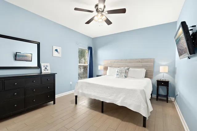a bedroom with a bed and a flat tv screen on dresser
