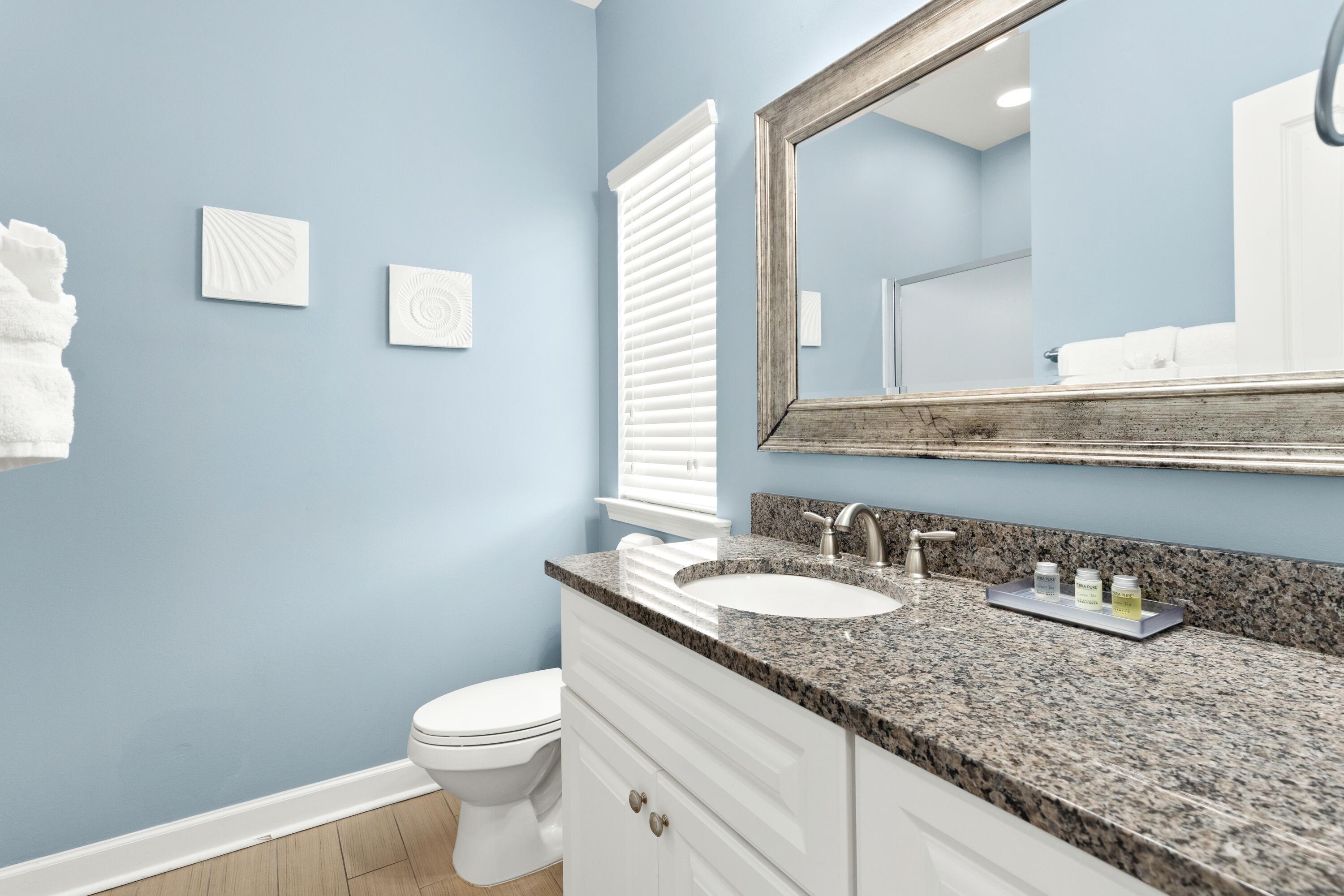207 Kono Way Destin, FL 32541 - Photo 27 of 45 a bathroom with a granite countertop sink a toilet and a mirror