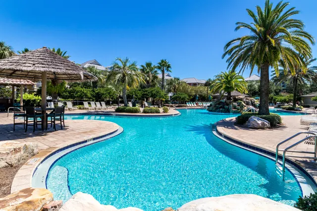 a view of a backyard with swimming pool and chairs