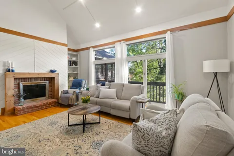 a living room with furniture a flat screen tv and a window