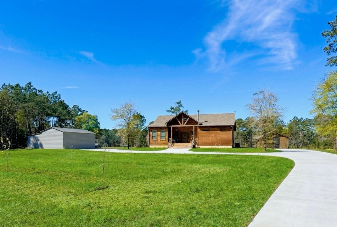 214 Hunters Hill Road Oakhurst, TX 77359 - Photo 3 of 29 a front view of a house with garden