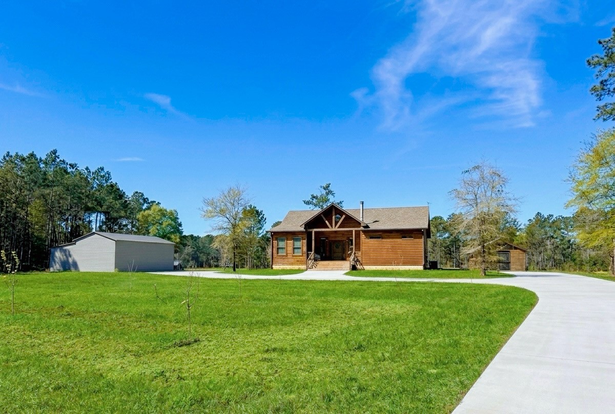 214 Hunters Hill Road Oakhurst, TX 77359 - Photo 3 of 29 a front view of a house with garden