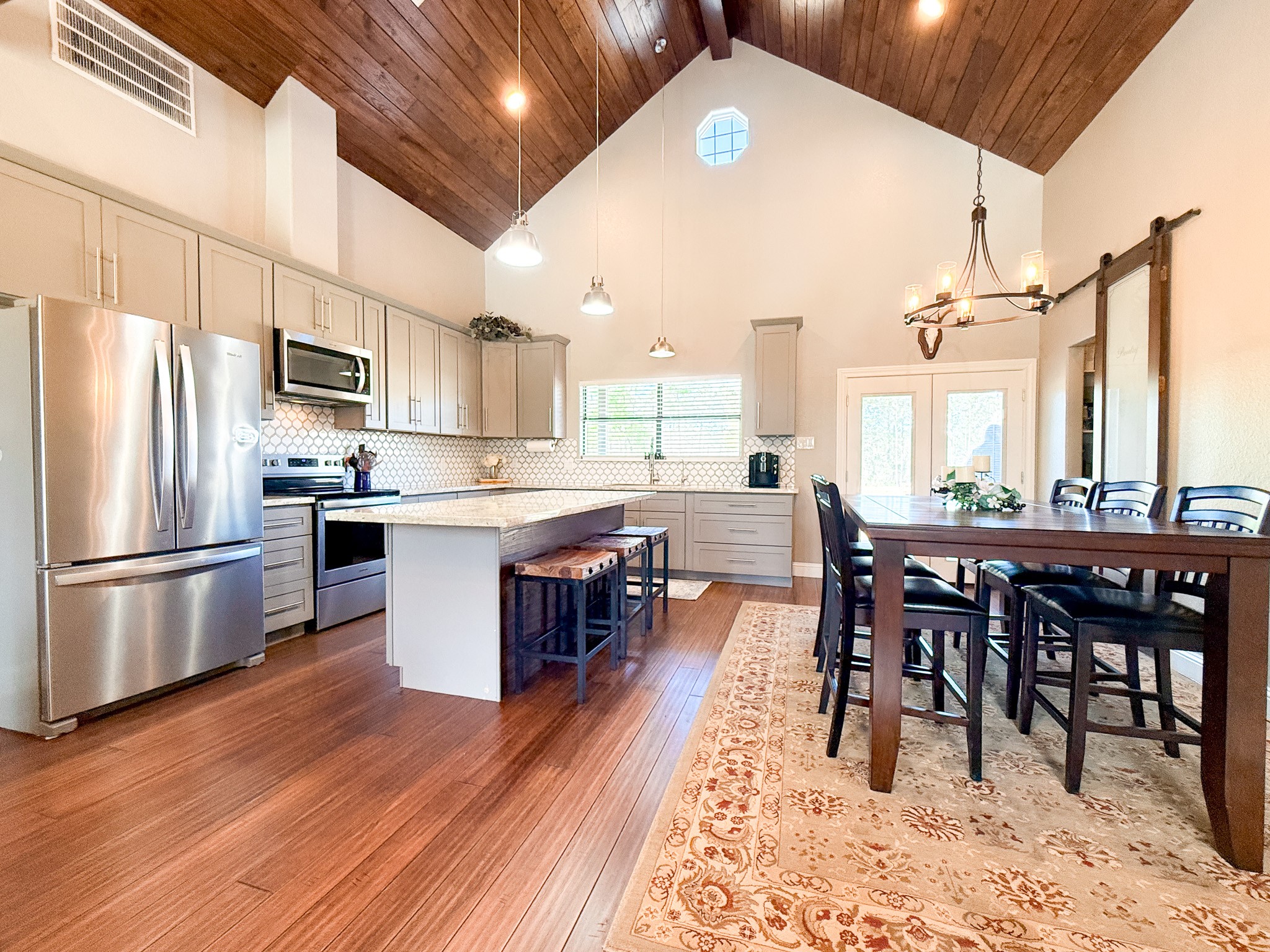 214 Hunters Hill Road Oakhurst, TX 77359 - Photo 8 of 29 a open kitchen with stainless steel appliances granite countertop a stove a refrigerator a sink a dining table and chairs with wooden floor