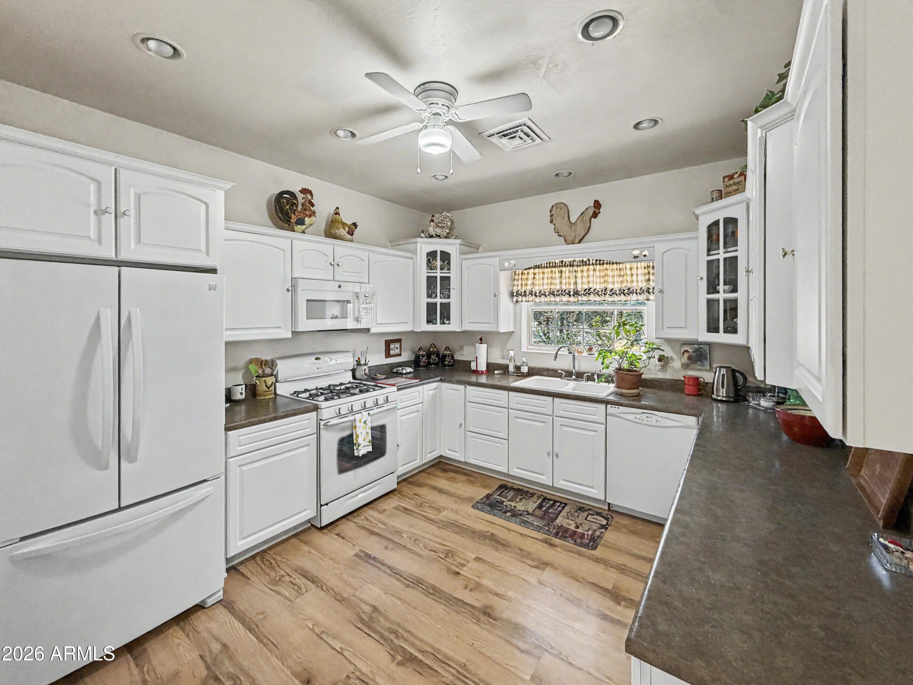2980 Pine Rim Road Heber, AZ 85928 - Photo 6 of 14 a kitchen with stainless steel appliances granite countertop a refrigerator a stove a sink dishwasher and white cabinets with wooden floor