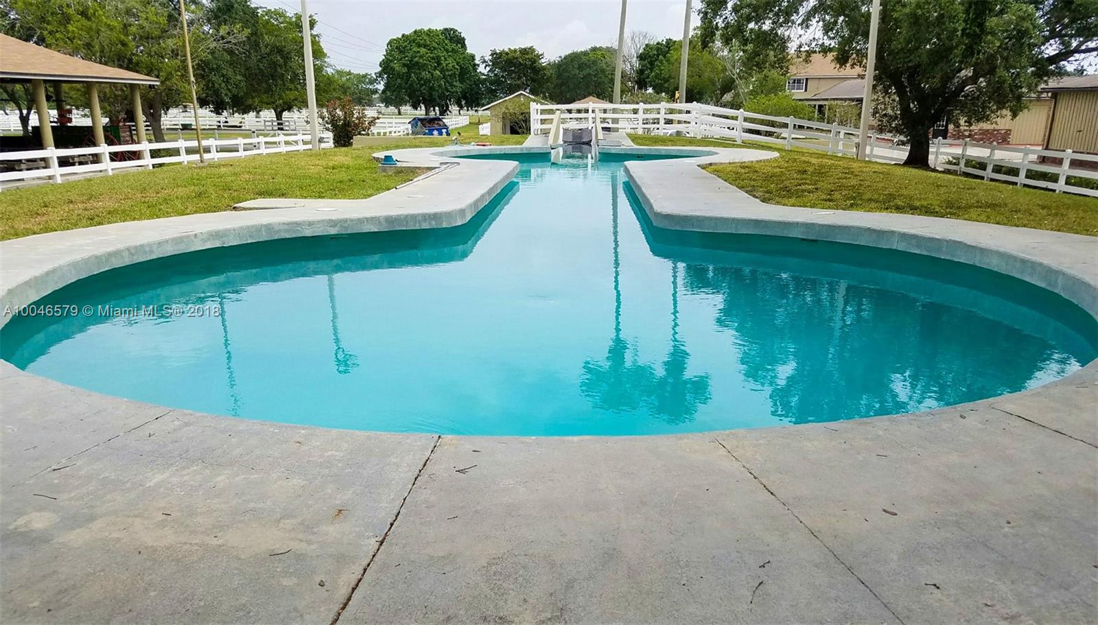 15990 Griffin Road Southwest Ranches, FL 33331 - Photo 5 of 20 a view of a swimming pool with a lounge chairs in a patio