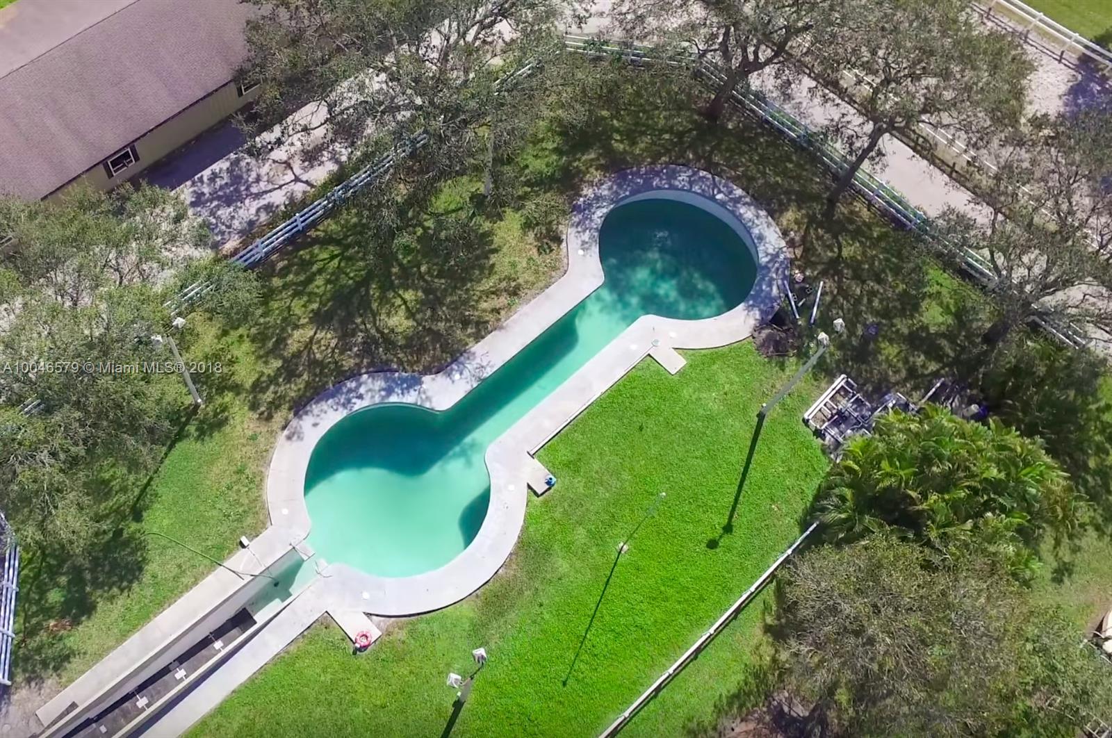 15990 Griffin Road Southwest Ranches, FL 33331 - Photo 7 of 20 a backyard of a house with a garden and plants