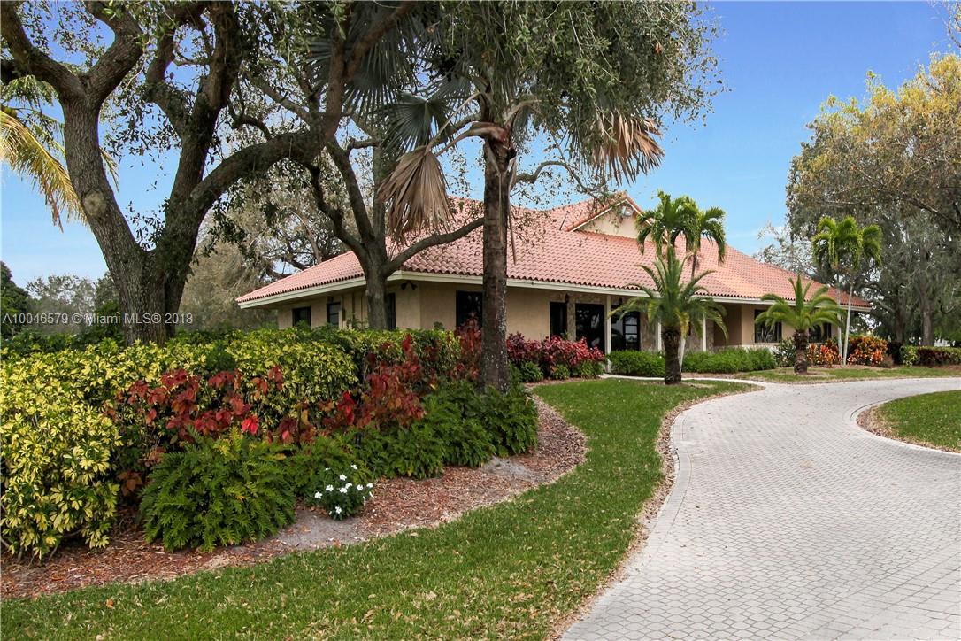 15990 Griffin Road Southwest Ranches, FL 33331 - Photo 8 of 20 a front view of a house with a yard and fountain