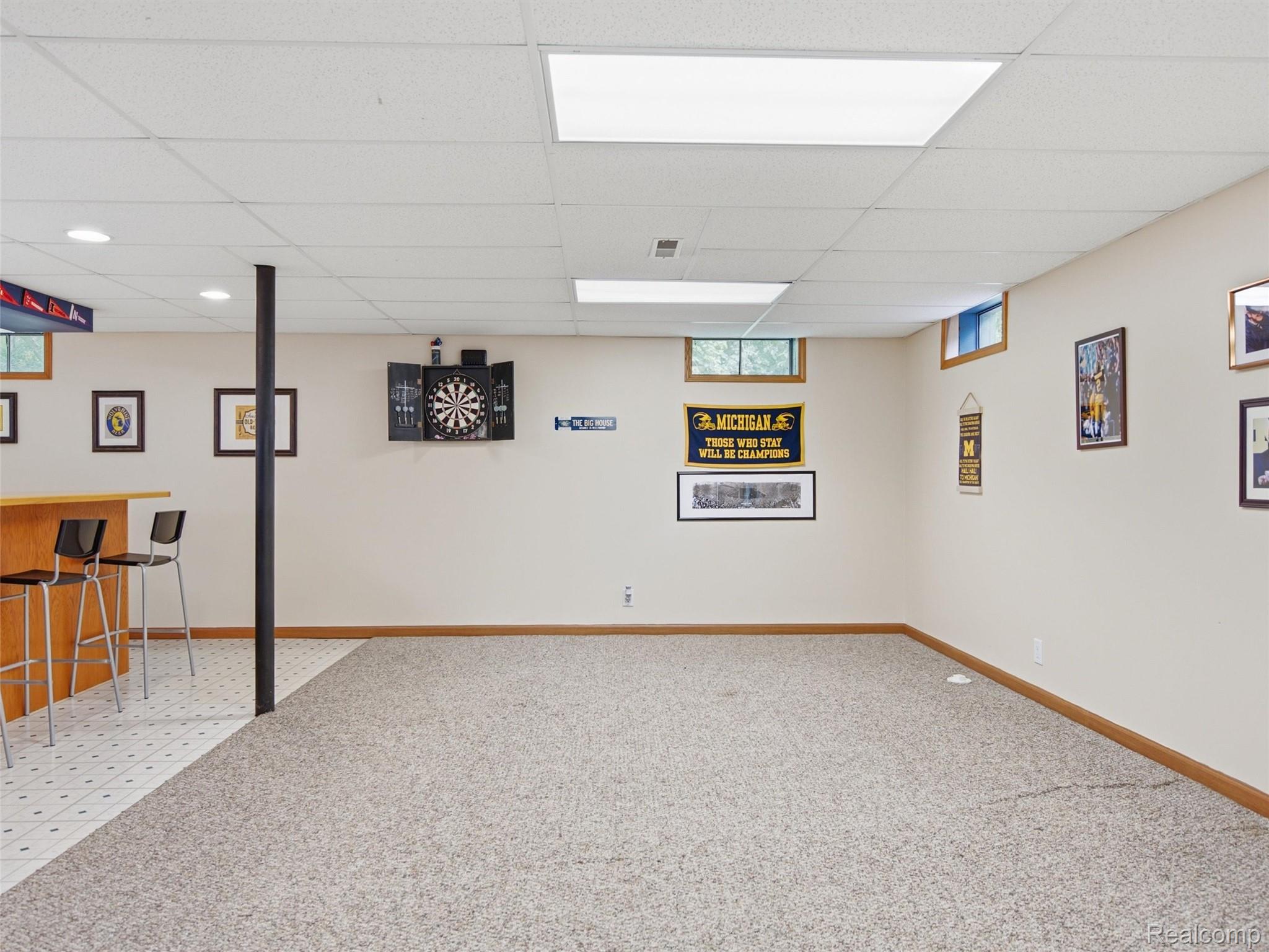 5003 Mason Road Howell, MI 48843 - Photo 29 of 59 Spacious finished lower level featuring a light wood-finish bar area with tiled flooring, neutral carpeting, recessed lighting, and drop ceiling panels
